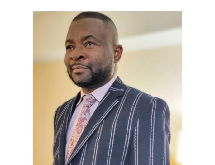 Picture of Dr Benard in Black Stripped jacket, pink shirt and a pink classic flying tie